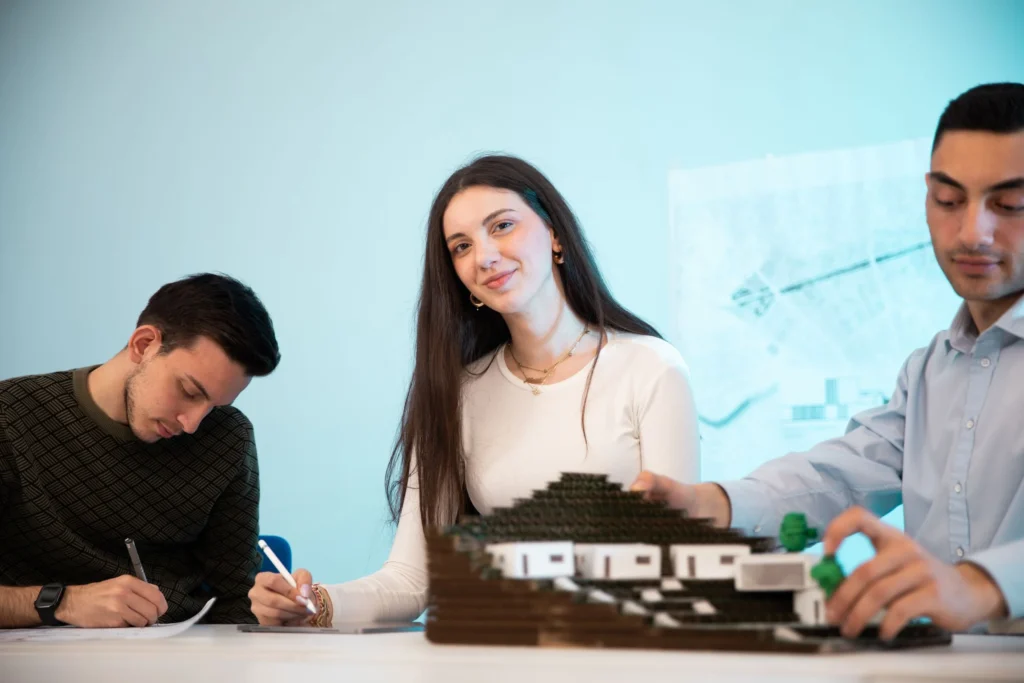 Tres personas colaborando en una maqueta en el taller de diseño