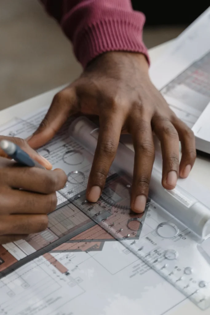 Persona dibujando un croquis arquitectónico de plantas con lápiz y regla