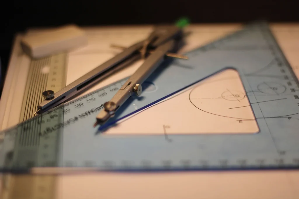 Compás y escuadra sobre un cuaderno en matemáticas para arquitectura