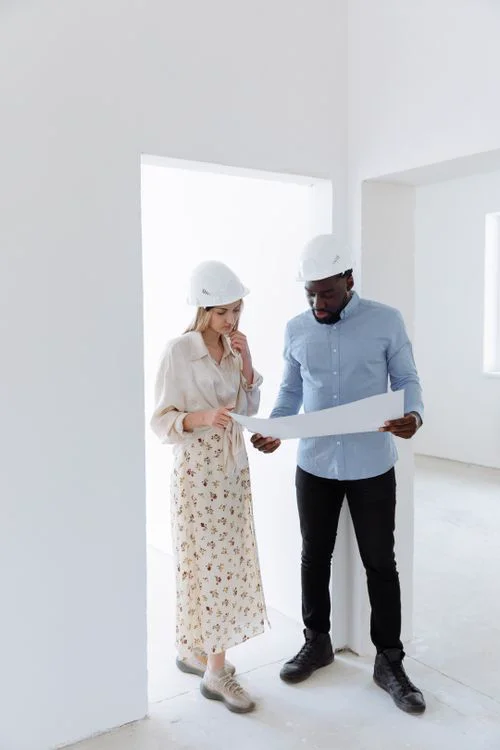 Arquitectos con cascos revisando un plano en obra