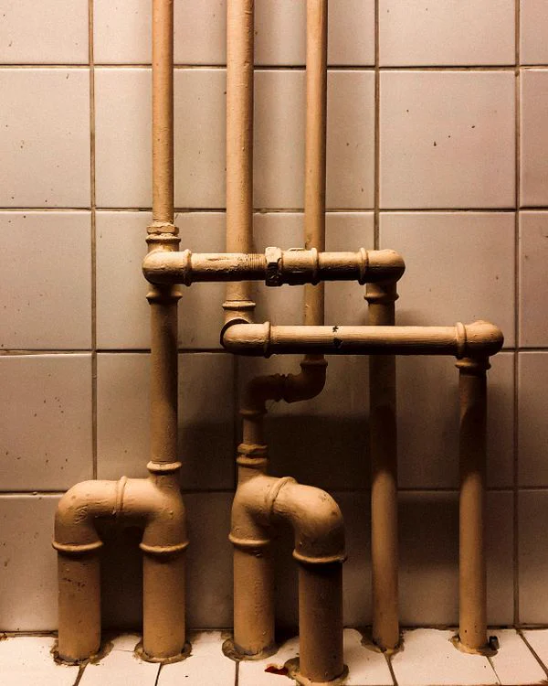 Tuberías de instalaciones sanitarias en pared de azulejos
